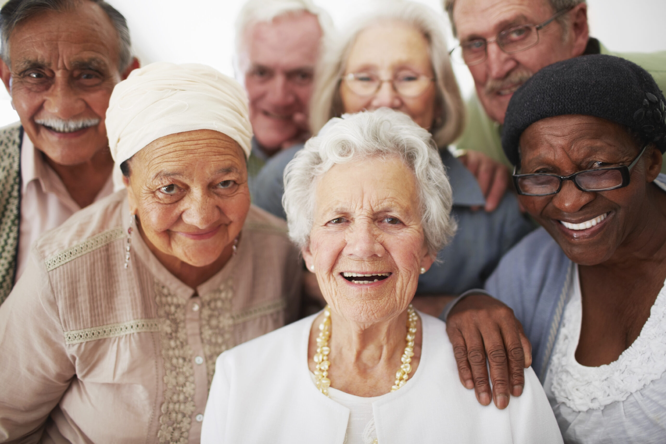 A group of seniors of different ethnicities looking at camera and smiling. 
